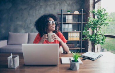 Woman sitting at her desk looking out the window while working from home office