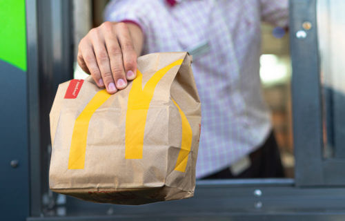 McDonald's drive-thru worker holding bag of food