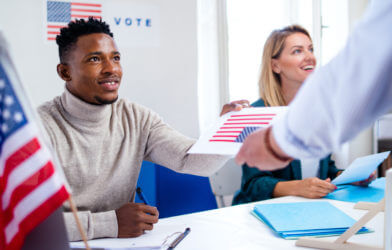 Polling place workers giving voters their ballots on Election Day