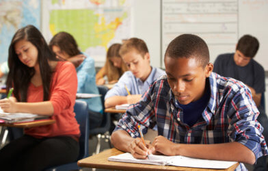 High school student studying, taking exam in class