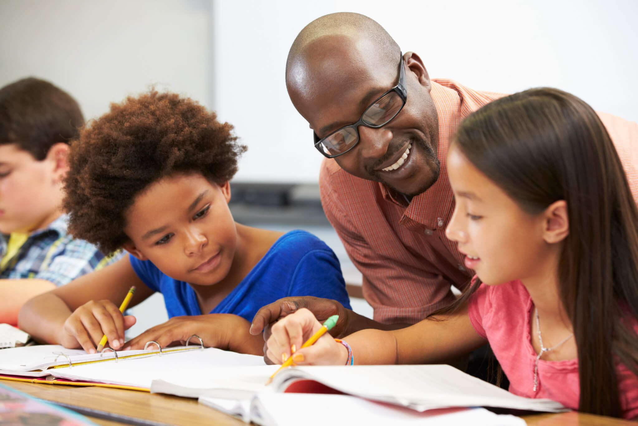 Teacher helping students in classroom at school