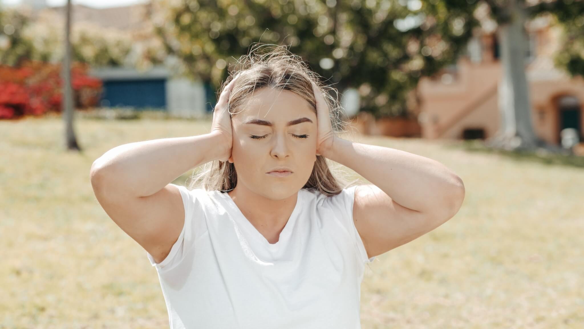 Woman covering ears, can't hear, too loud